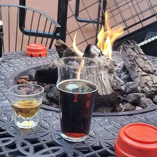 two glasses of beer and a fire pit