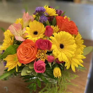 A bright and cheery arrangement in a low, clear cube. Starting at $49.99