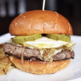 a hamburger with pickles and an egg