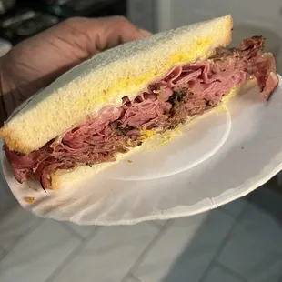 Combination Pastrami and Corned Beef on white bread w/ mustard, mayo, onions, and Swiss cheese.