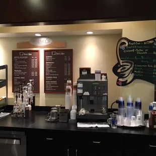 a coffee shop with a menu on the wall