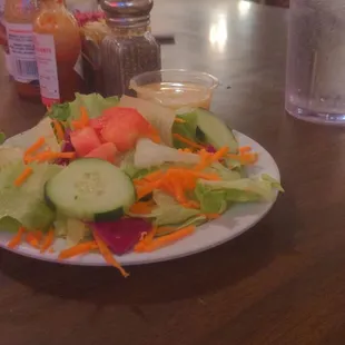 A plate of salad on top of table.