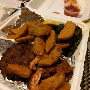 Fried seafood platter with wedges and collard greens