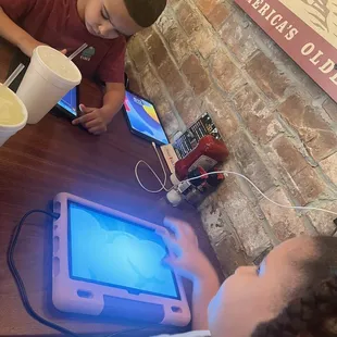 Kiddos waiting on their food. Even a port to charge their pads