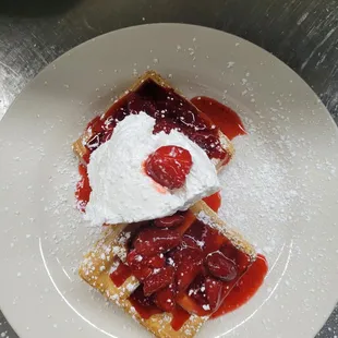 a plate of food with powdered sugar on top