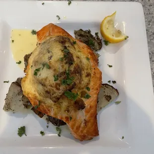 Broiled Salmon stuffed with Scallops, lump crab meat and Shrimp on top of potatoes in garlic sauce.