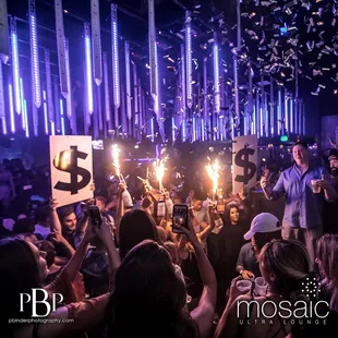 a crowd of people holding up sparklers