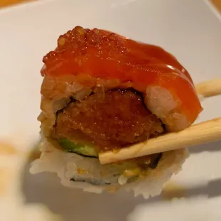 Geisha Roll - spicy tuna and avocado; topped with salmon, yuzu tobiko, unagi sauce