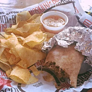 Barbacoa burrito on a wheat tortilla with black beans, queso, lettuce, jalapeños, black olives, and roasted red pepper salsa.