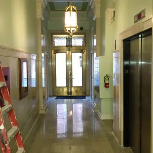 View from interior of the main hallway. The front door is locked with a with a number pad for entry.