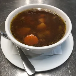 a bowl of soup on a plate with a spoon