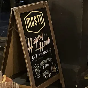a sign for a happy hour at a restaurant