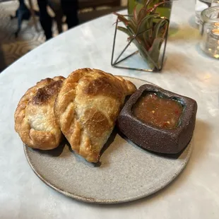 a plate of pastries and dipping sauce