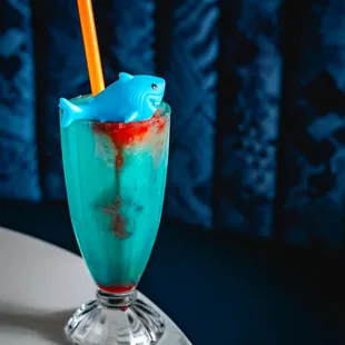 a blue drink with a shark in it