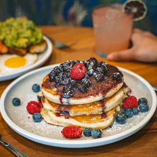 a stack of pancakes with berries and blueberries