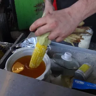 Roast Corn in dip into Butter