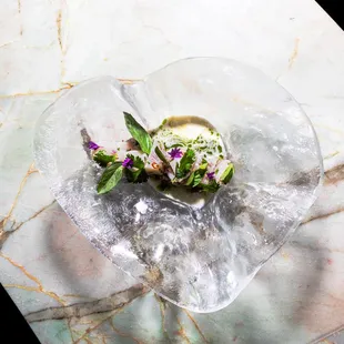 a bowl of salad on a marble table