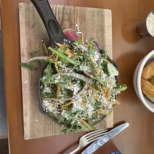 a wooden cutting board with a salad on it