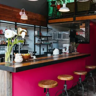 a pink bar with stools