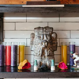 a shelf with candles and a statue