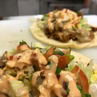 two tacos with dressing