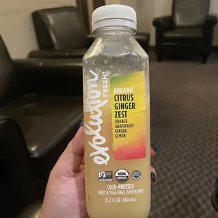 a hand holding a bottle of juice