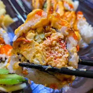 a close up of a plate of sushi with chopsticks
