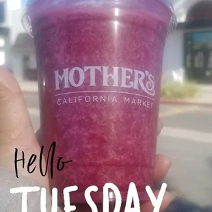 a hand holding a pink smoothie