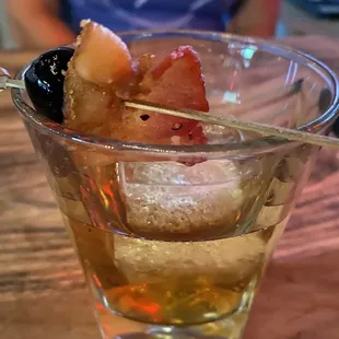The Drunk Piggy: bourbon, apple simple syrup, plum and black walnut bitters with candied bacon and a Luxardo cherry, in a smoked glass