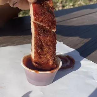 a hand holding a piece of meat