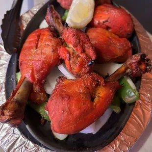 a plate of chicken with a lemon wedge