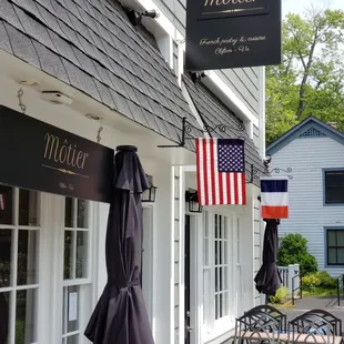 the outside of a restaurant with tables and umbrellas