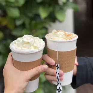 two people holding coffee cups