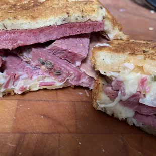 REUBEN (house-made corned beef, Swiss cheese, sauerkraut, 10,000 island dressing, on grilled rye bread)