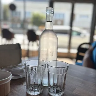 a bottle of water and glasses
