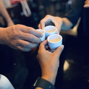 two people holding cups of coffee
