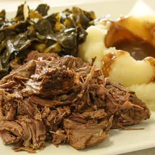 a plate of roast, mashed potatoes and collar greens