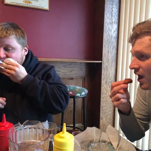 Patrick eats chicken fingers with human fingers, Erik's sausage pita LINKS him to his Balkan heritage.