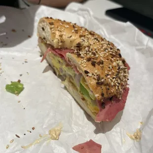 a half eaten sandwich on a piece of paper