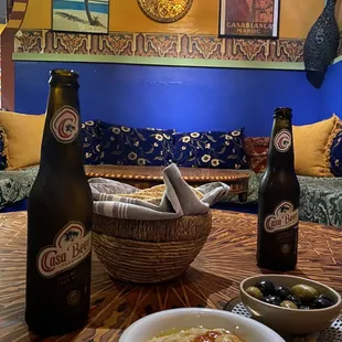 a bowl of soup and two bottles of beer