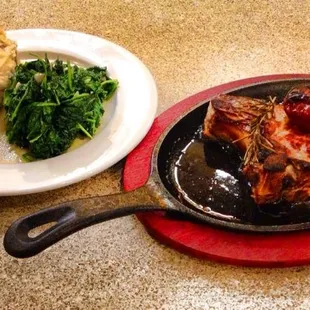 Our Bone-in Pork Chop paired with red-skinned mashed potatoes and sauteed spinach.