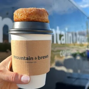 a hand holding a cup of coffee