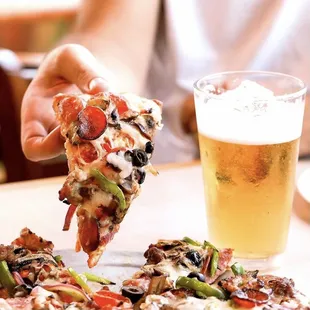 a hand holding a slice of pizza