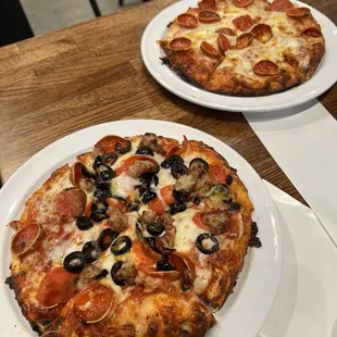 Mini pizzas; one pepperoni and one pepperoni, sausage, and olive.