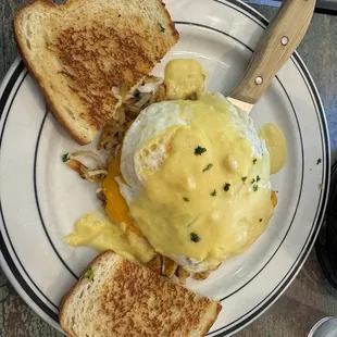 Chicken Cordon Bleu Skillet with eggs over medium, hollandaise sauce and sour dough toast