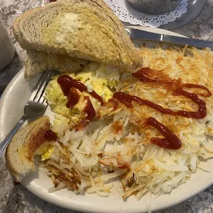 Scrambled eggs, hash browns, and toast.