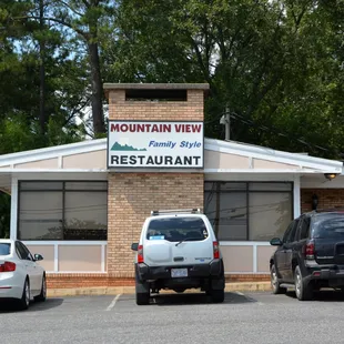 two cars parked in front of the restaurant