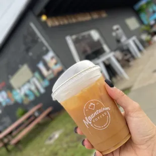 a hand holding a cup of coffee
