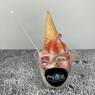 Vanilla soft serve with magic strawberry dust in a cup with a cone