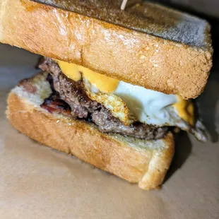 Rise and Shine - 
 Local grass fed beef, fried egg, sliced avocado, bacon, and sriracha mayo on Texas Toast